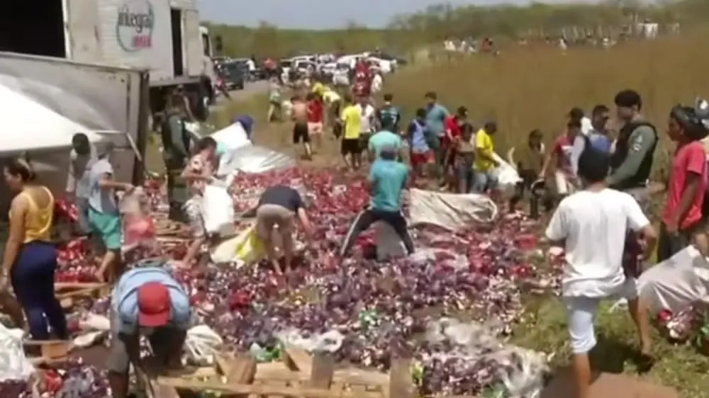 Caminhão tomba no Ceará e população saqueia carga de cerveja na frente da polícia